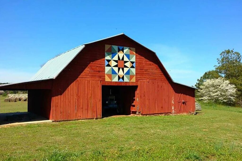 a large size barn quilt hangs above the barn door.