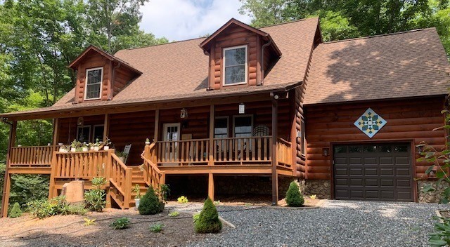 A beautiful wooden house with a clear view of barn quilt hanging on the garage.