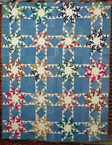 a swallow wings quilt hung up by metal clips