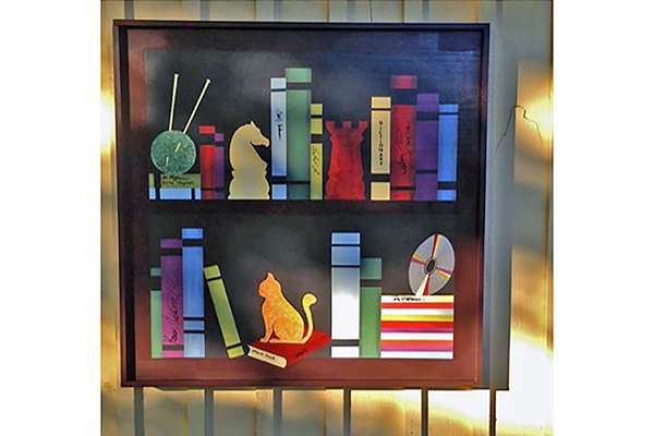 a barn quilt with bookshelves patterns hanging on the metal frames.