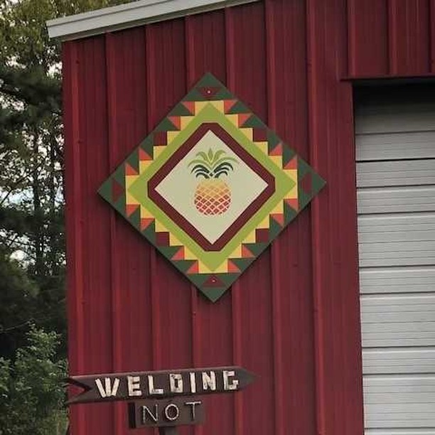 a pineapple barn quilt hanging beside the barn door.
