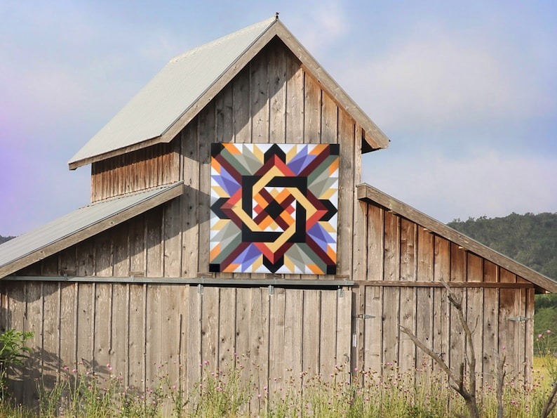 a vibrant quilt hanging on the barn