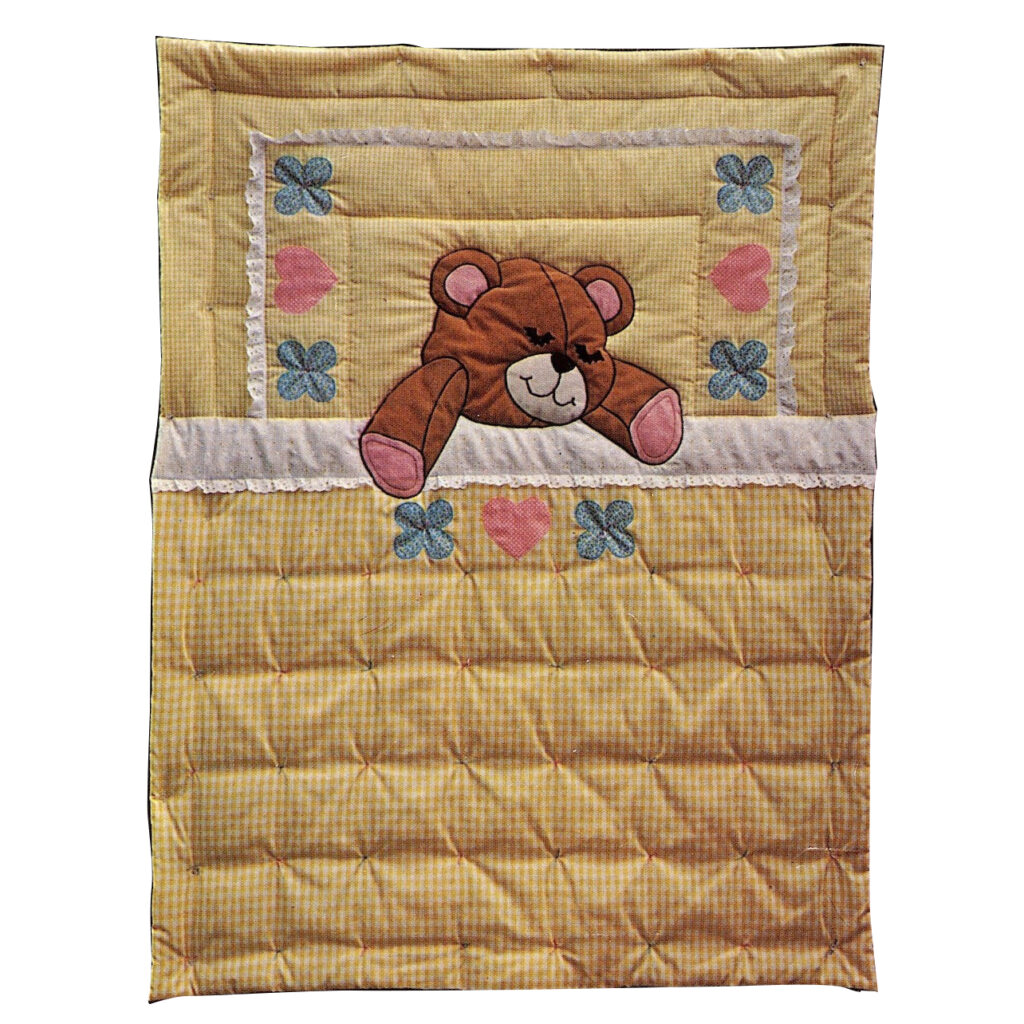 An adorable quilt pattern featuring a sleepy teddy bear taking a nap