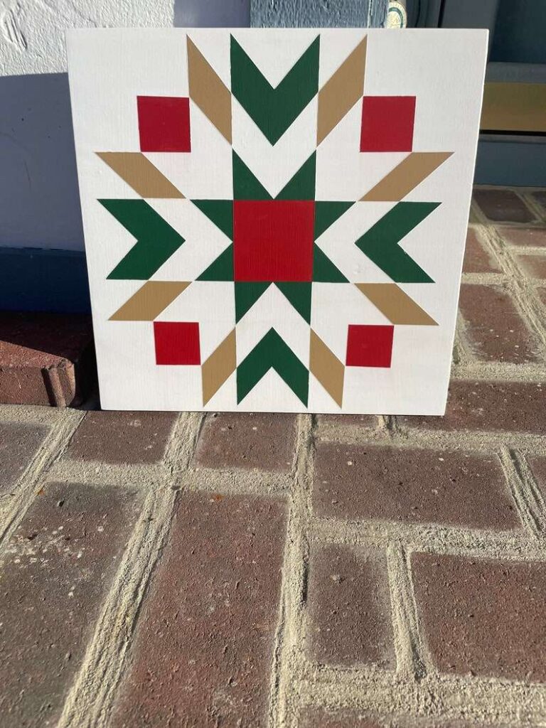 a barn quilt with the star pattern placed on the brick floor, leaning against the wall.