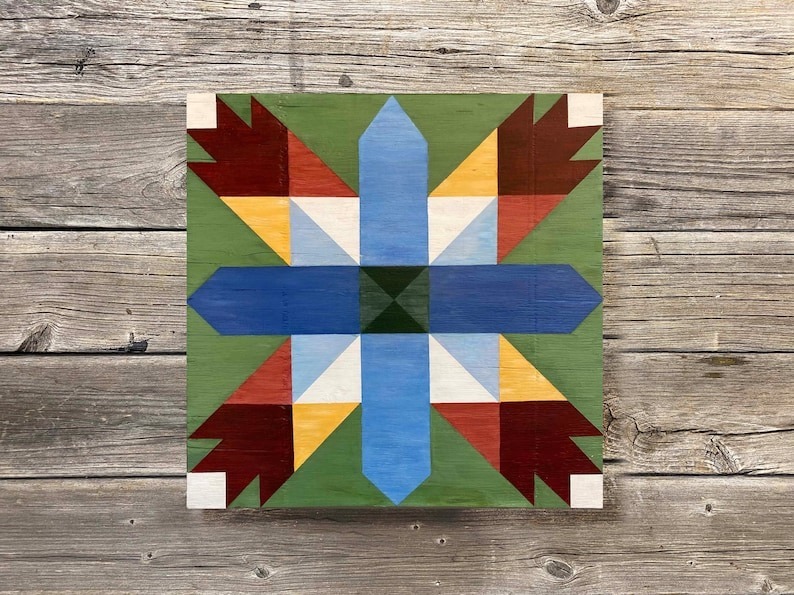 a small barn quilt laying on the wooden floor