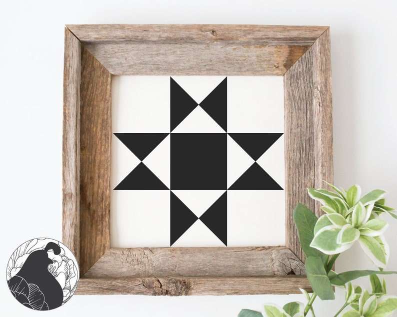 a small barn quilt with a black star pattern placed after a bough.