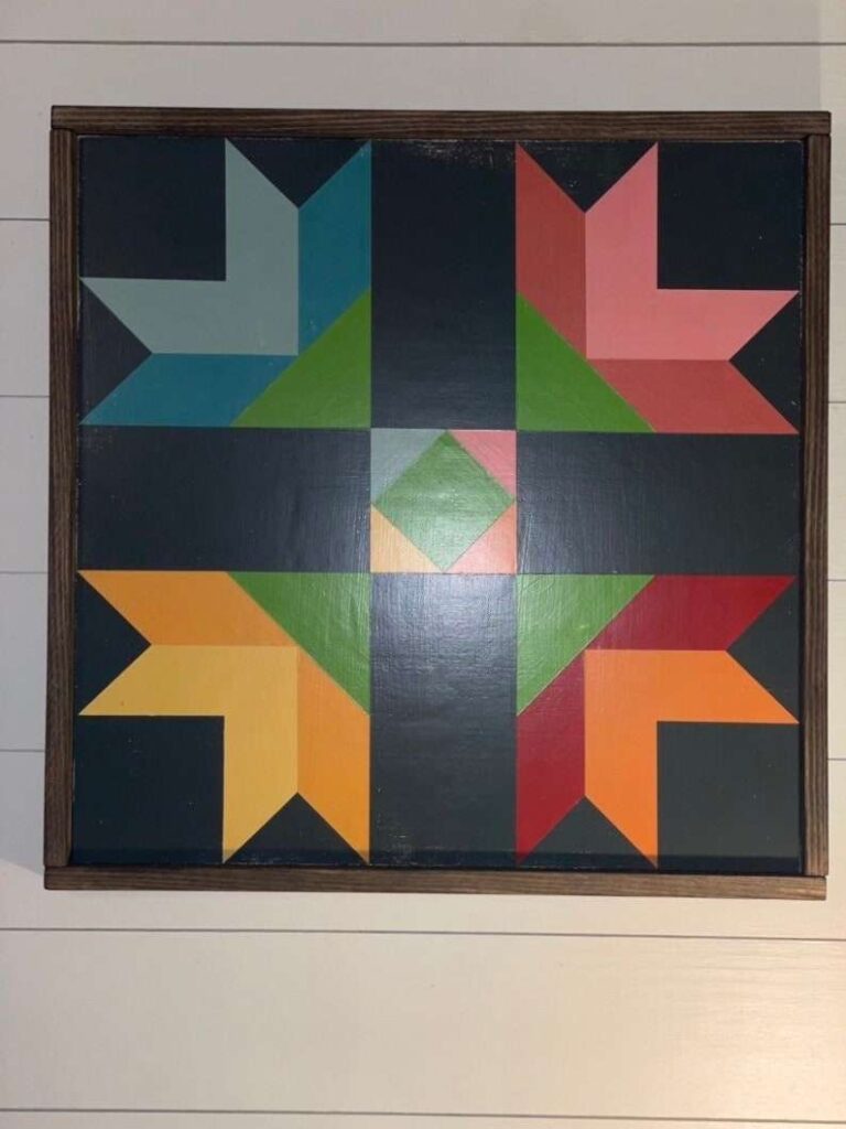 a barn quilt with four flowers pattern laying on the floor