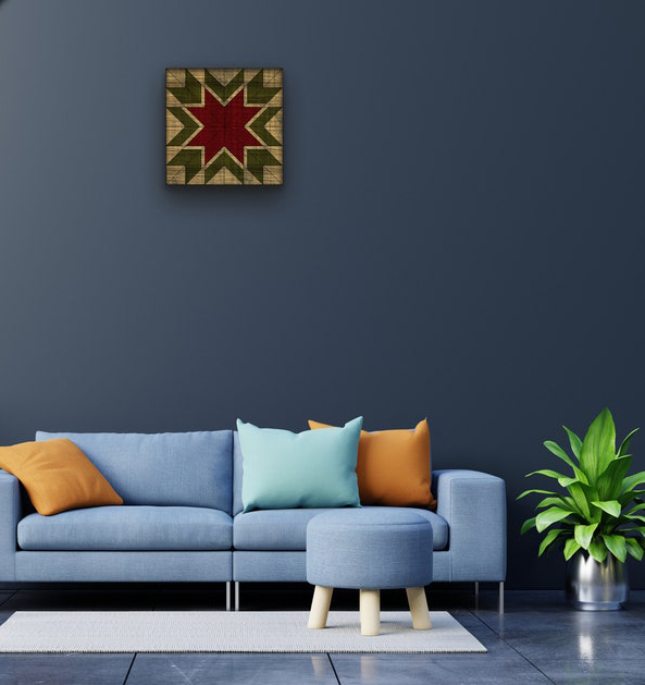 a small barn quilt hanging on the wall, above a sofa.