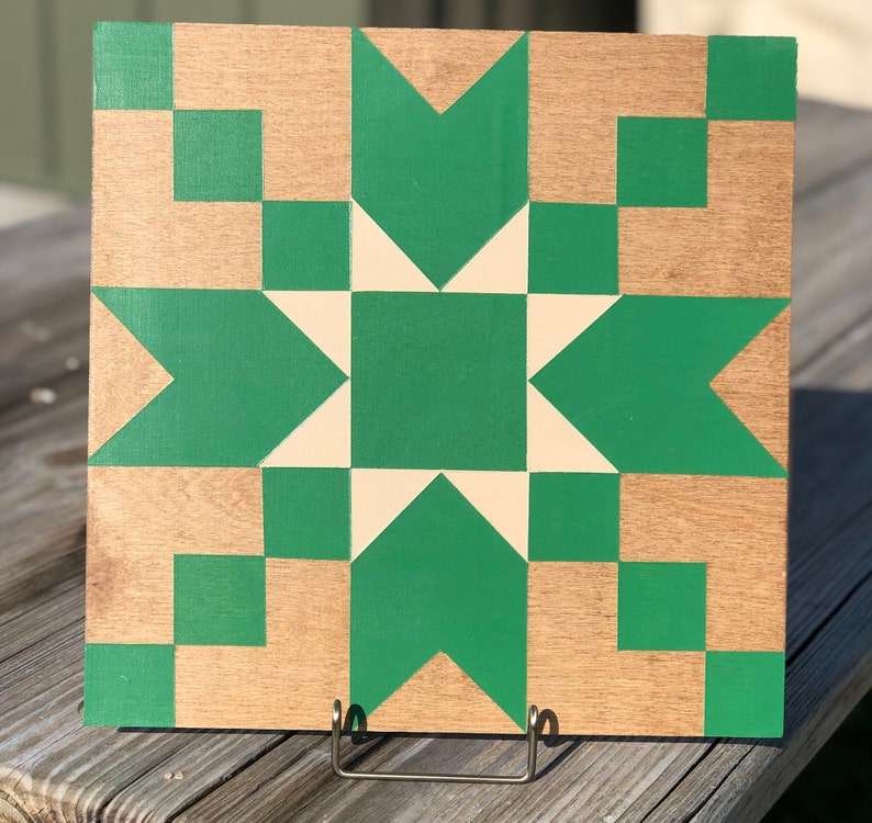 a small barn quilt with the teal star pattern placed on the metal rack above the wooden table.