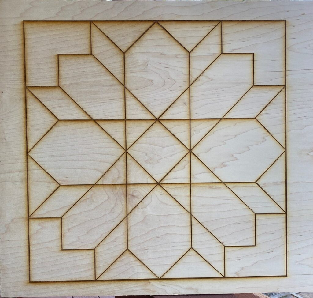 The rough wooden barn quilt has a laser beam, and the shapes on the painting combine to form a flower.