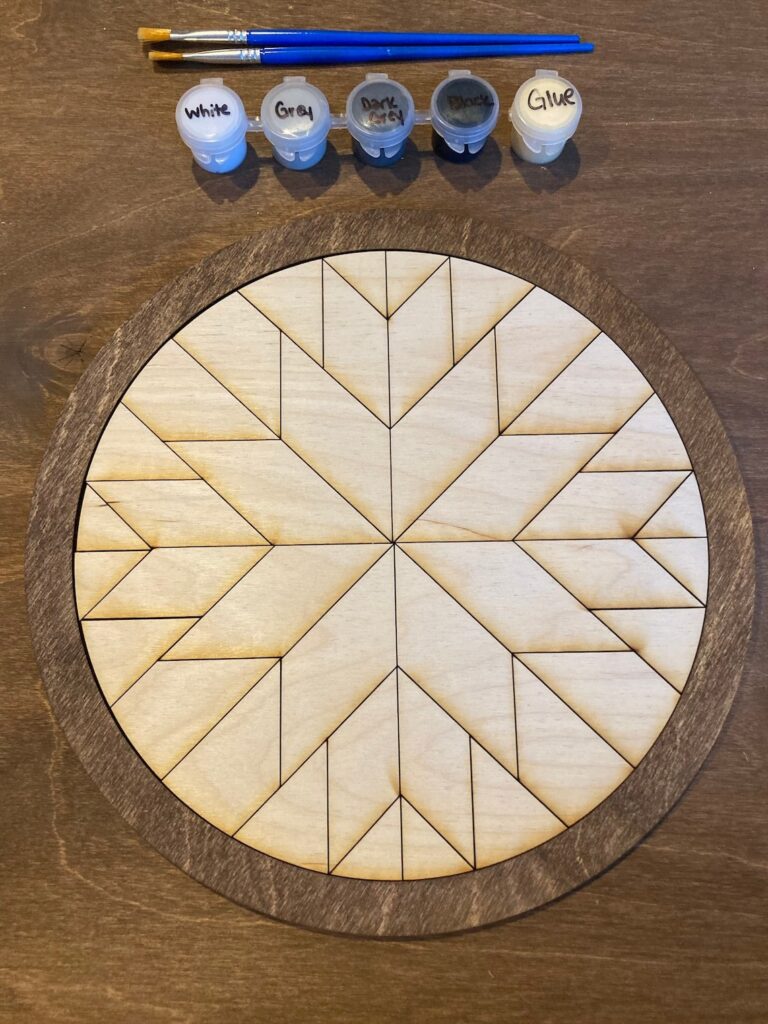 The round barn quilt has blocks assembled into many petals.