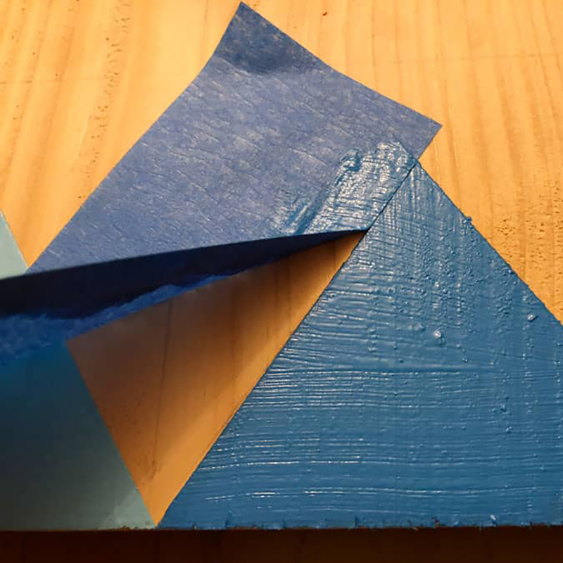 A sheet of blue tape is being peeled off