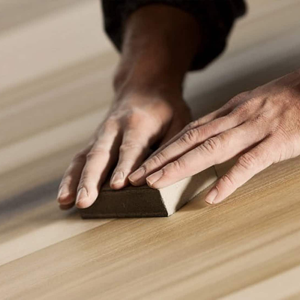 2 hands sand smooth the surface a wooden plank