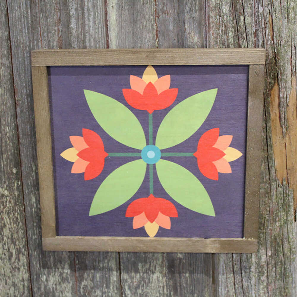a barn quilt with four red flowers pattern hanging on the wooden wall