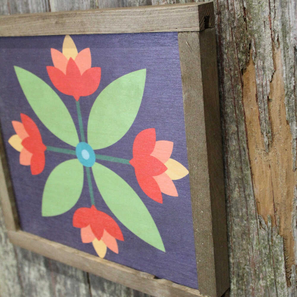 a corner of a barn quilt with four red flowers pattern