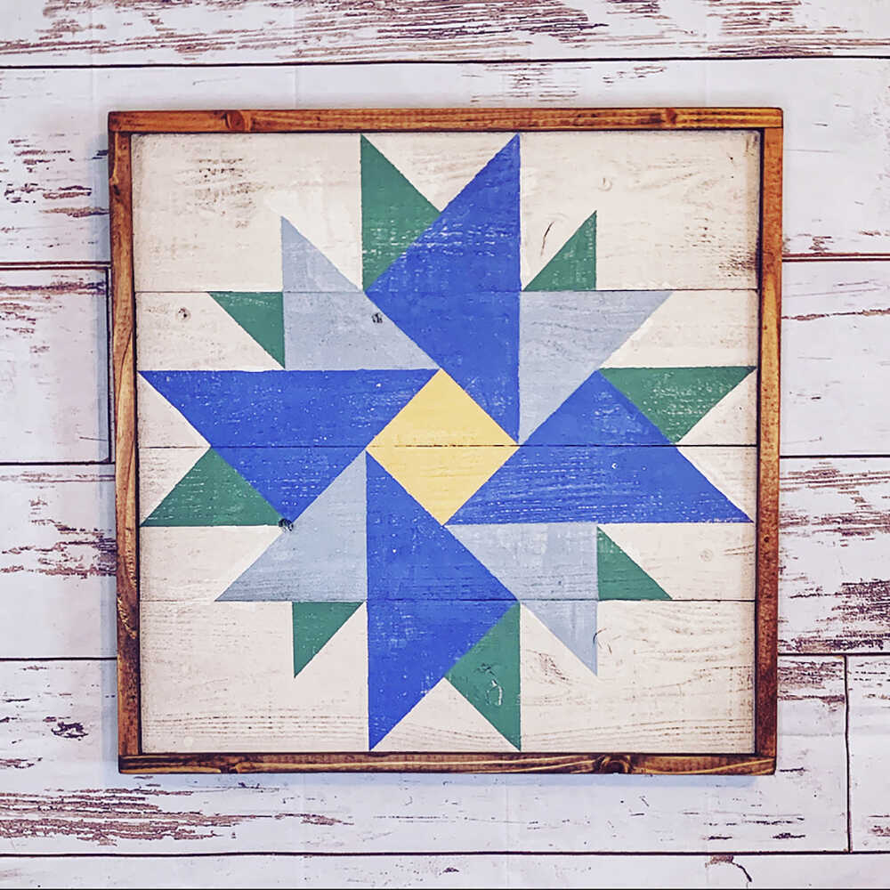 a barn quilt with colorful pattern hanging on the wooden wall