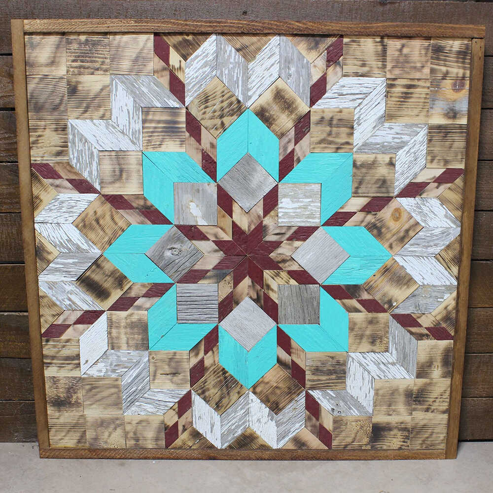 a barn quilt with colorful flower pattern leaning against wooden wall