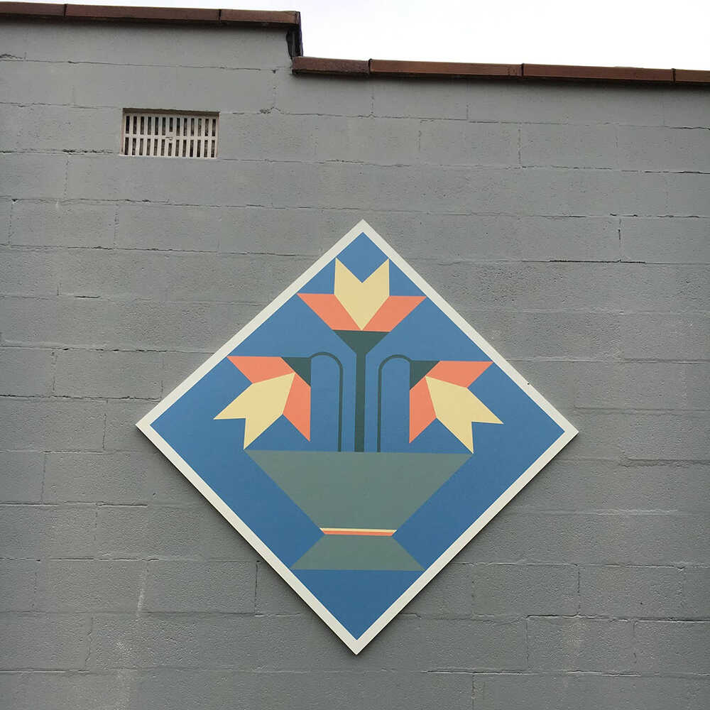 a barn quilt with lilies flower pot pattern hanging on the barn