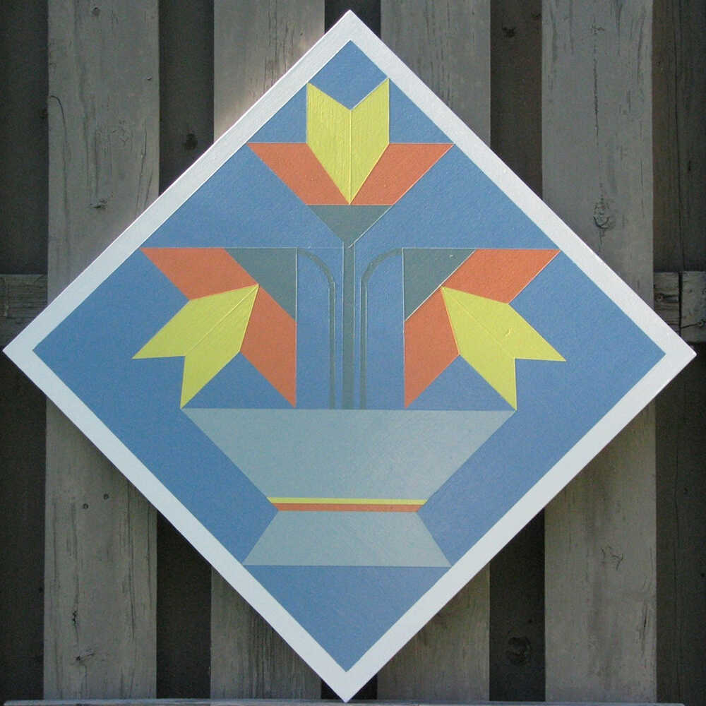 a barn quilt with lilies flower pot pattern hanging on the wooden wall