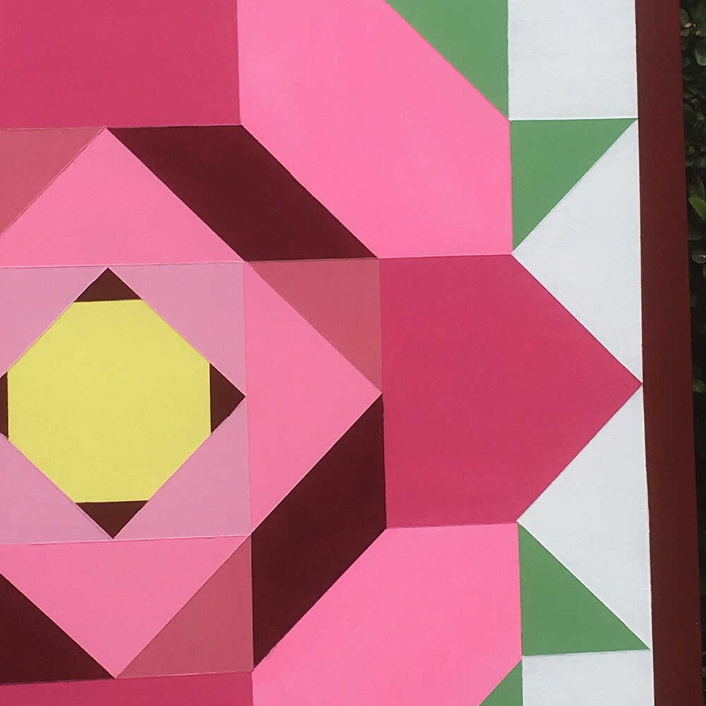 a corner of a barn quilt with rose flower pattern