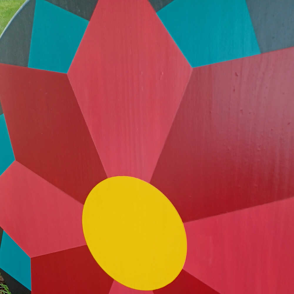 a corner of barn quilt with red flower pattern