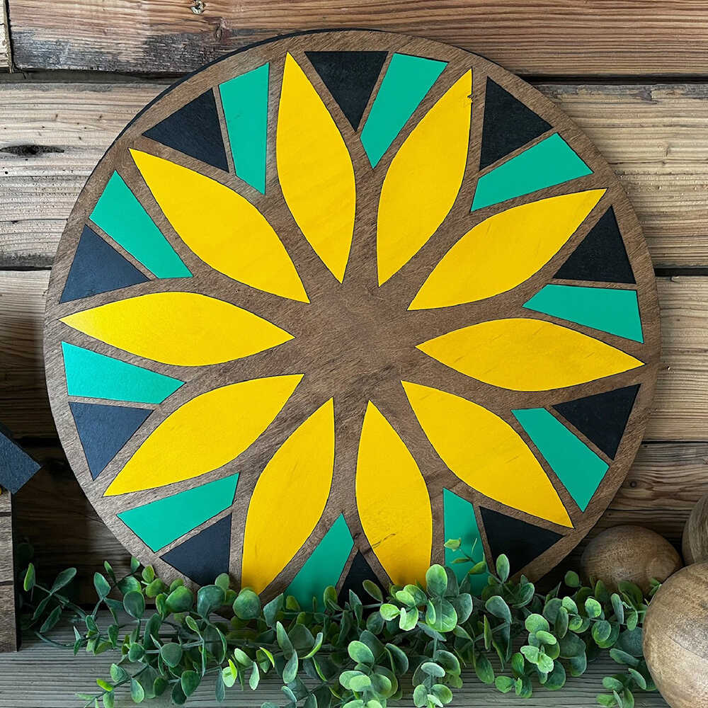 a round barn quilt with yellow flower pattern leaning against wooden wall