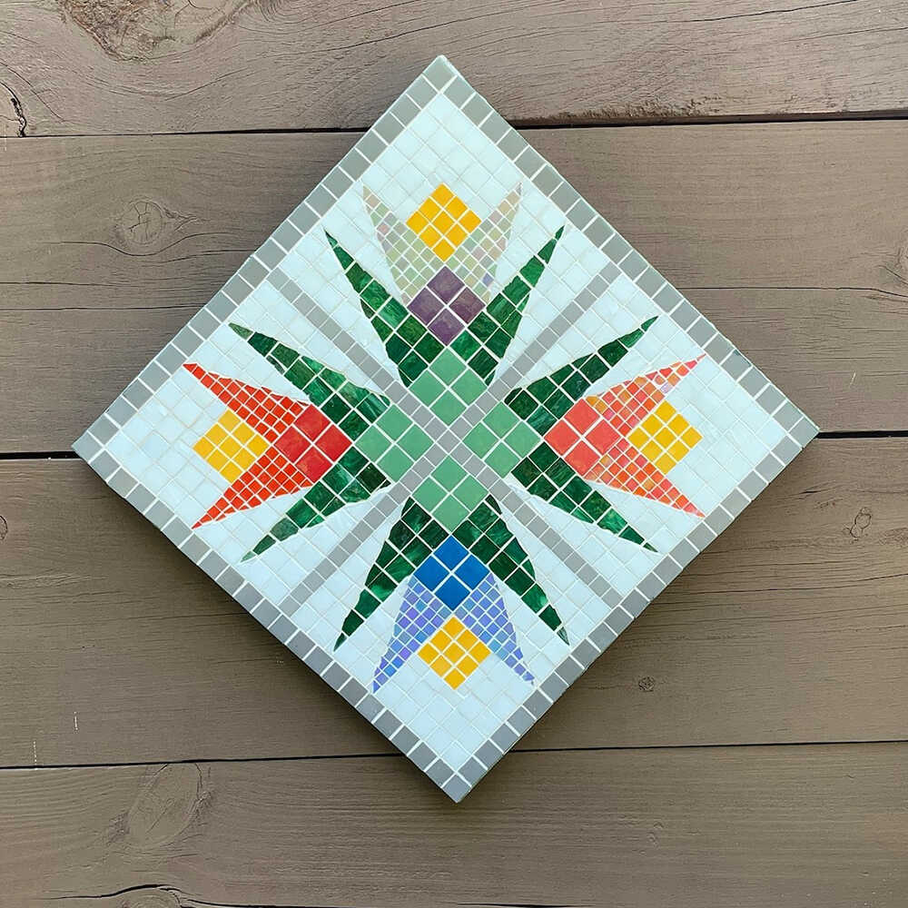 a barn quilt with four lilies pattern hanging on the wooden wall