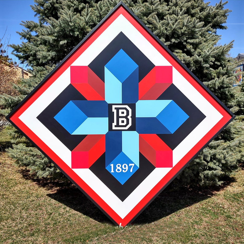 a barn quilt blue-and-red-cylindrical pattern and Initials placed in the garden