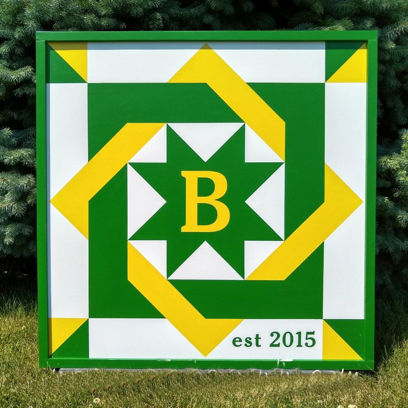 a barn quilt with nested squares pattern - blue and yellow