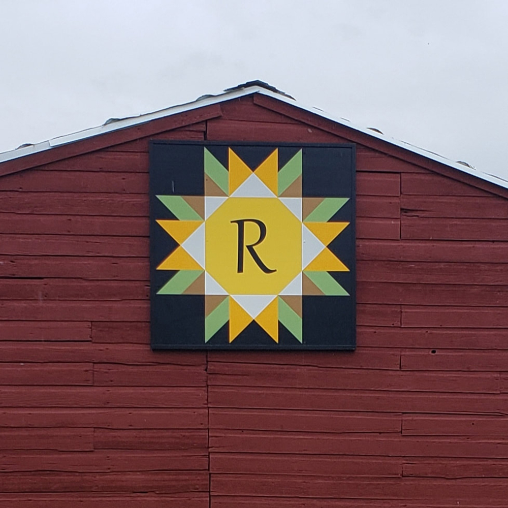a sunflower barn quilt hanging on the barn