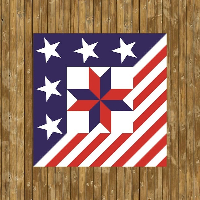 a barn quilt hanging on the wooden wall