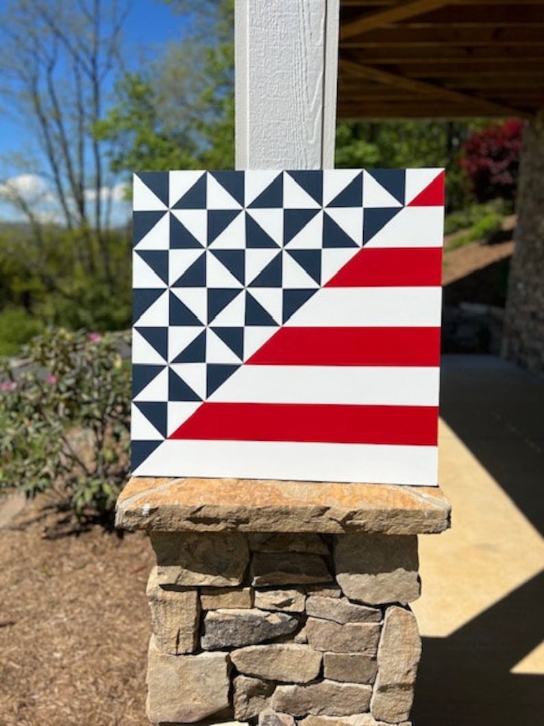 a barn quilt placed on stone pillars