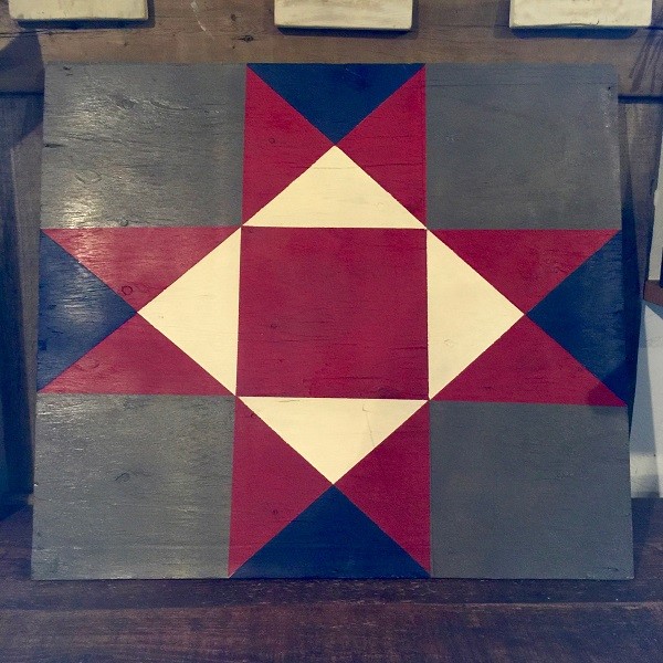 a barn quilt placed on the wooden floor