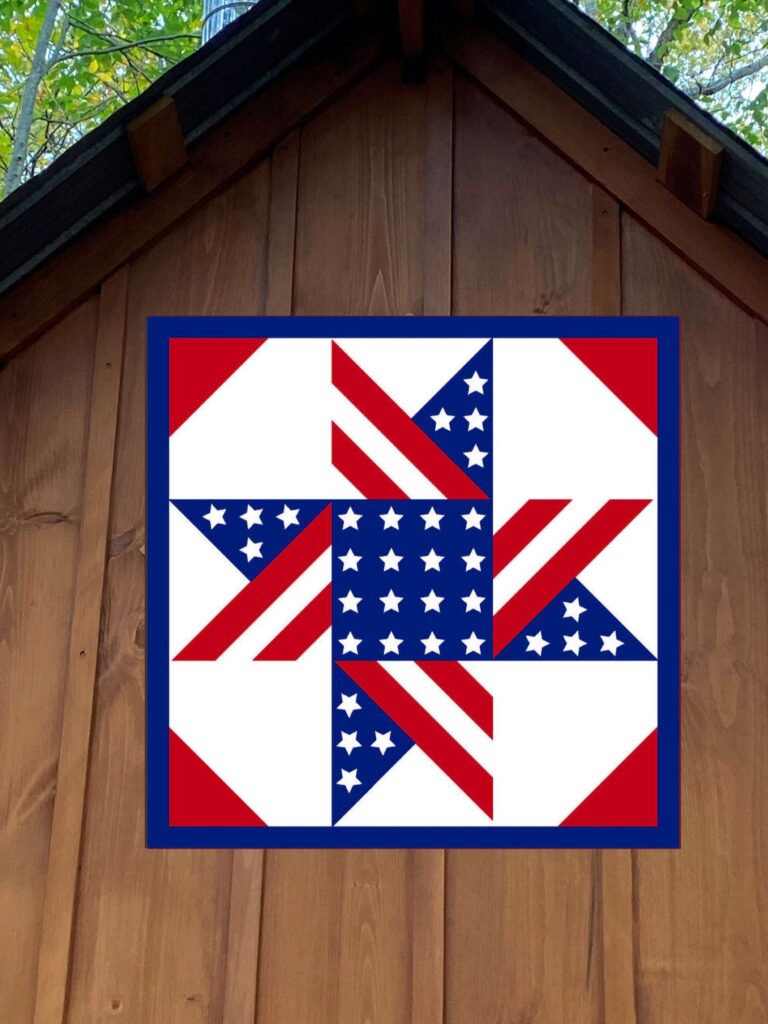 a barn quilt  American Flag pattern hanging on the wooden barn