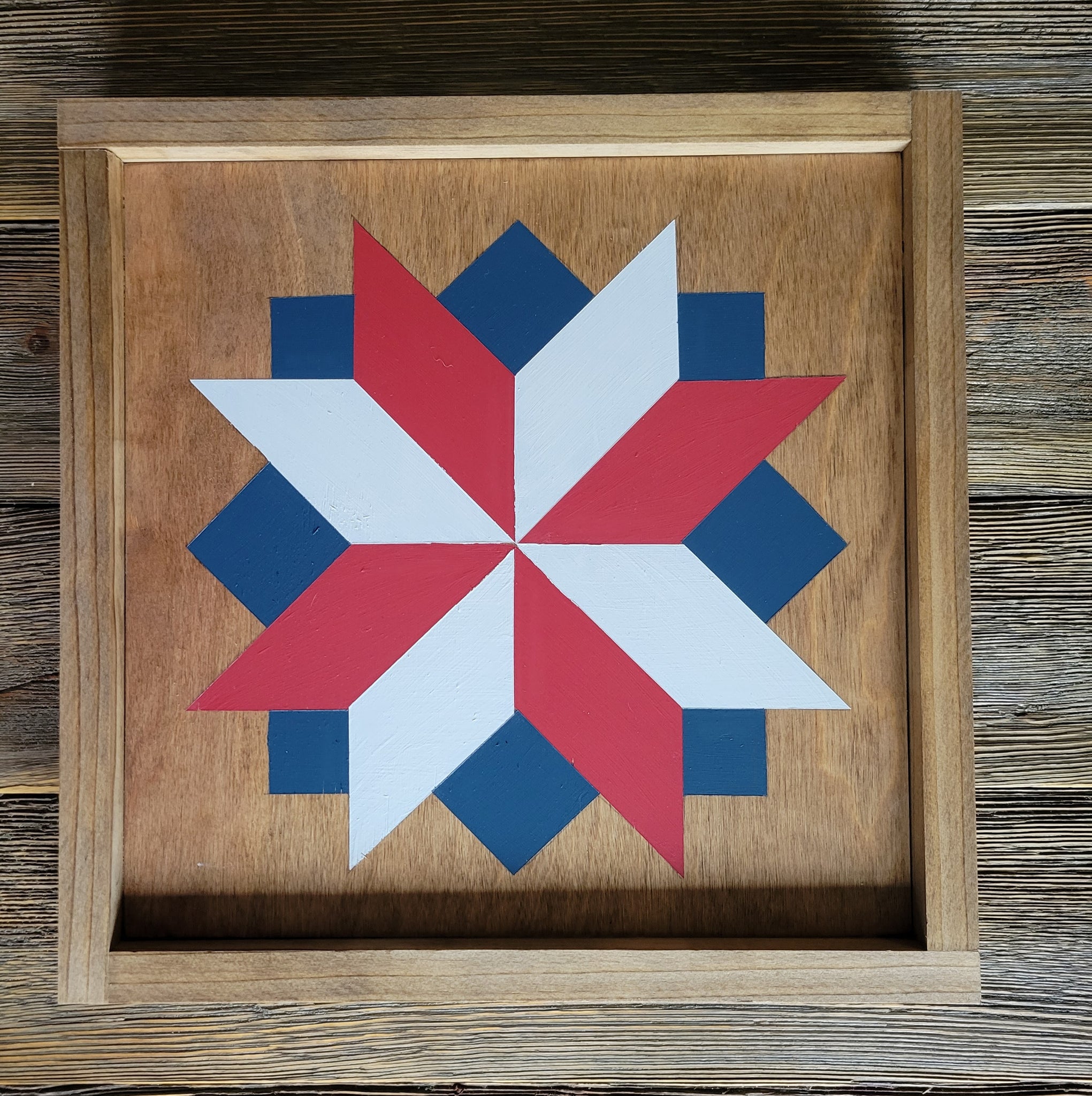 a barn quilt laying on the wooden floor
american flag colors as stars