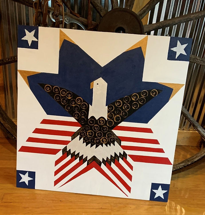 a patriotic bald eagle barn quilt placed on the floor