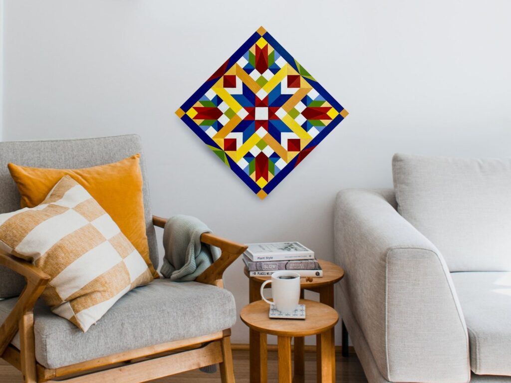 a spring rising barn quilt hanging on the wall, between an armchair and a sofa.