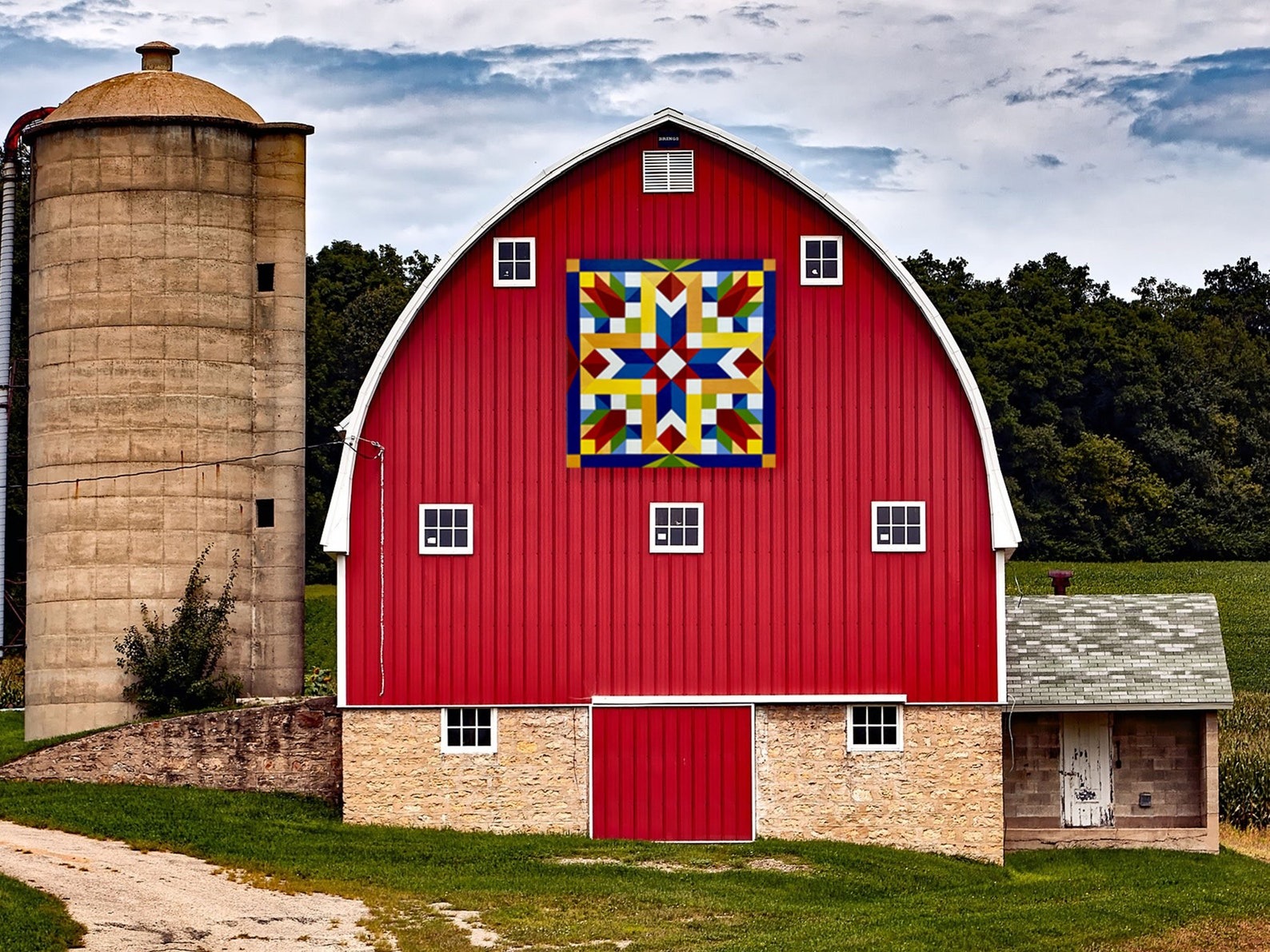 a spring rising barn quilt hanging on the barn