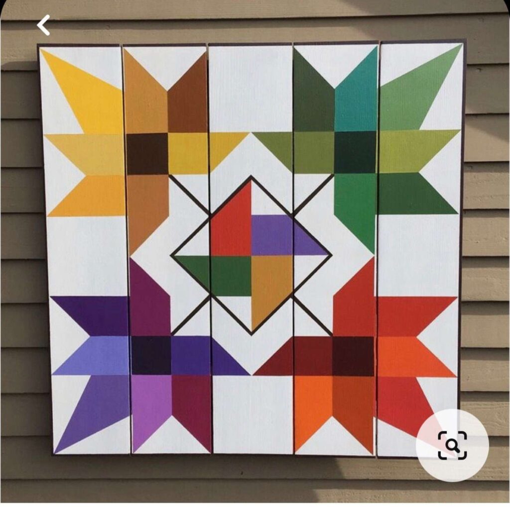 a maple leaf barn quilt hanging on the wall