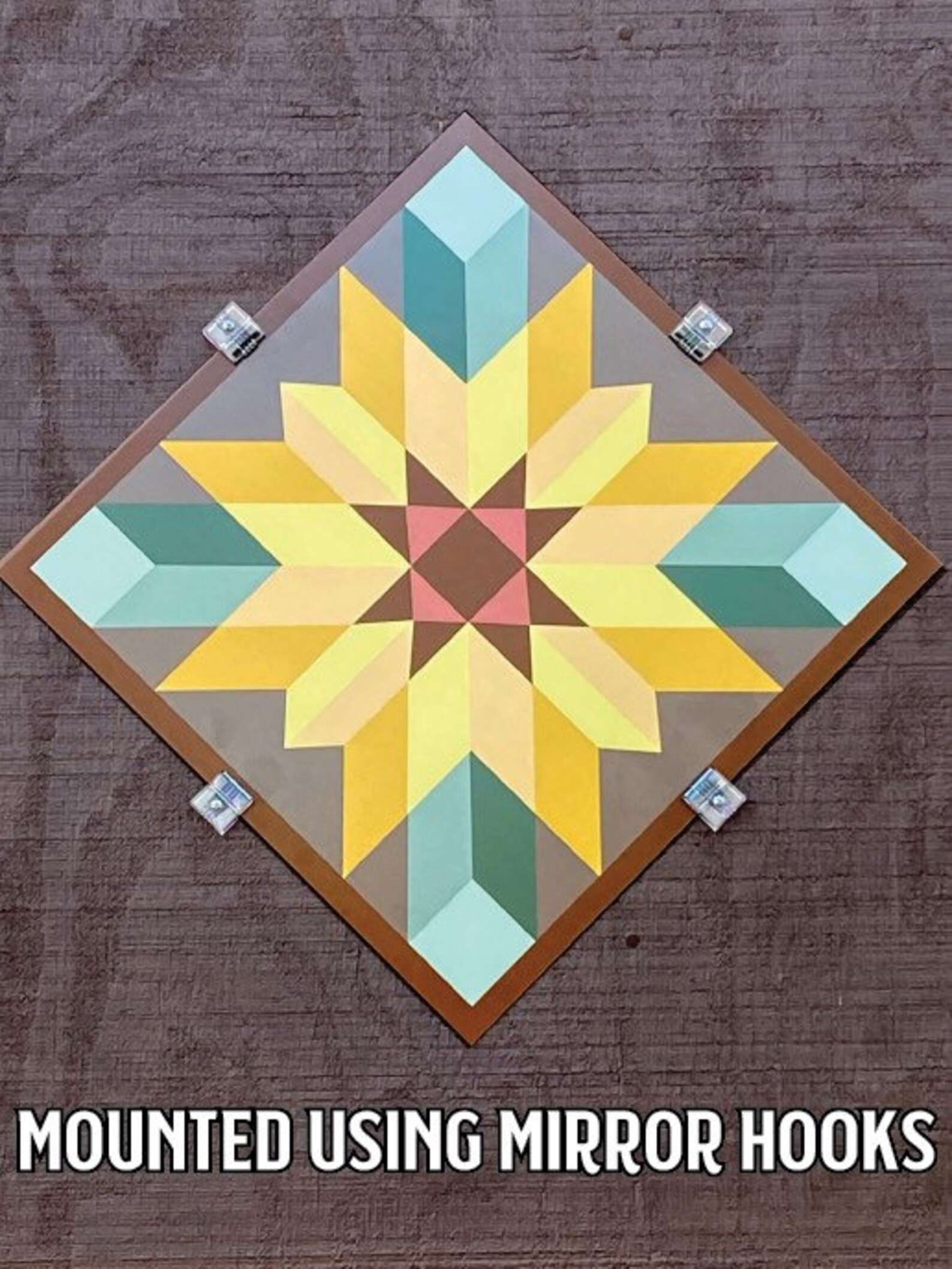 a barn quilt mounted on the wooden wall by mirror hooks