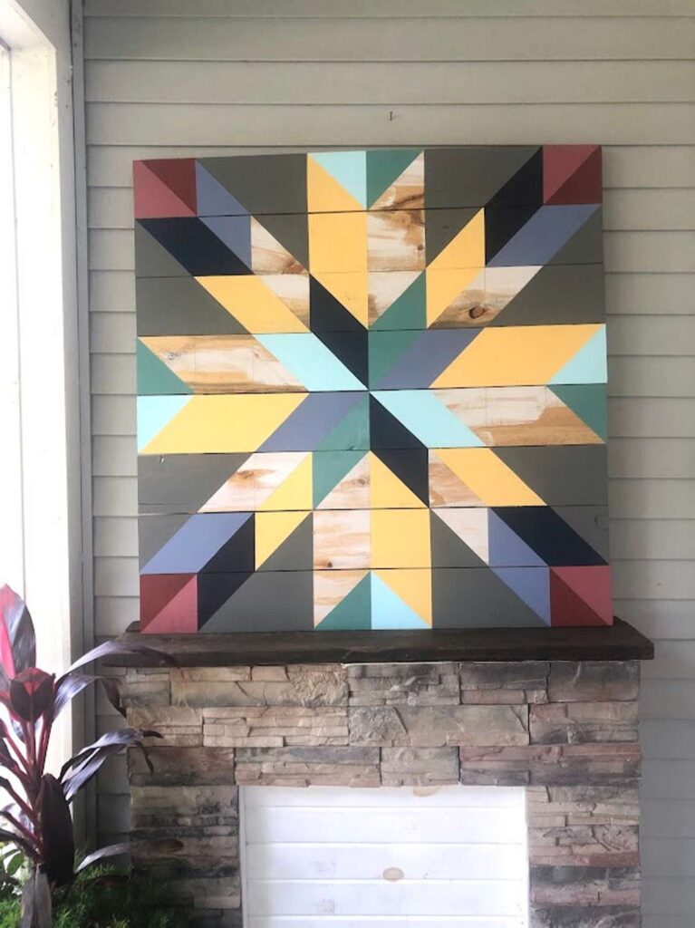 a barn quilt placed on the wooden shelf, mounted on the wall