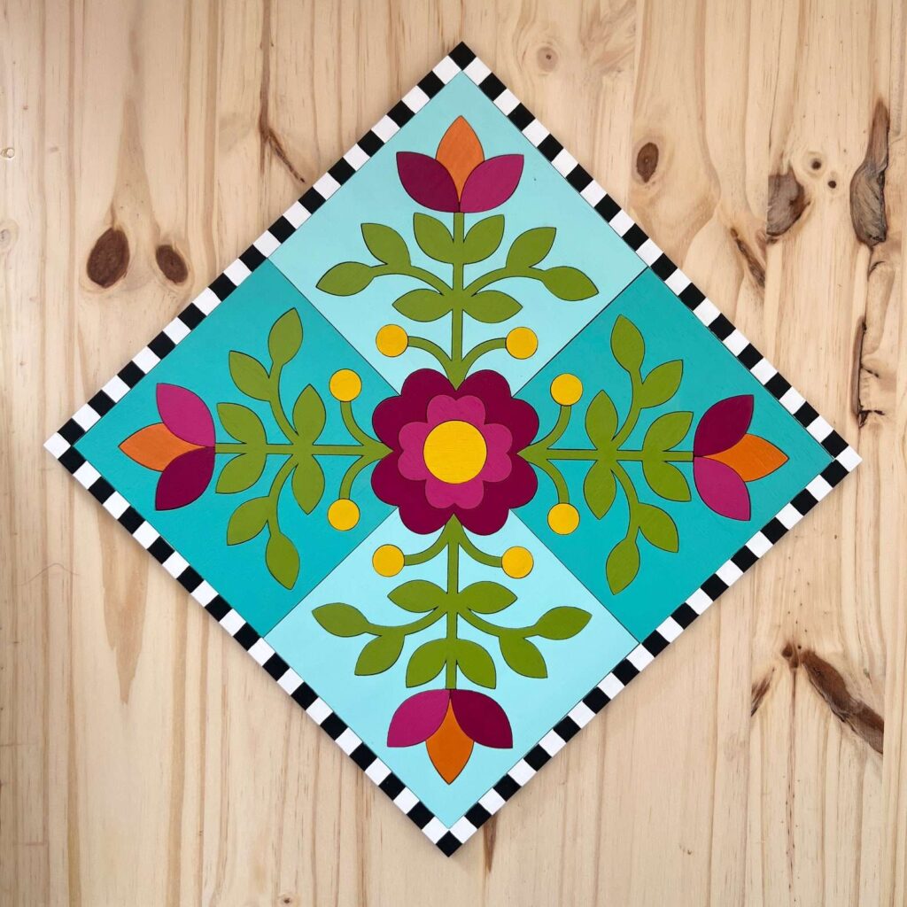 a flower barn quilt hanging on the wooden wall