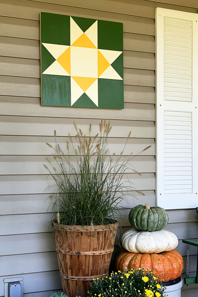 a white and yellow star barn quilt hanging on the wall, next to the window
