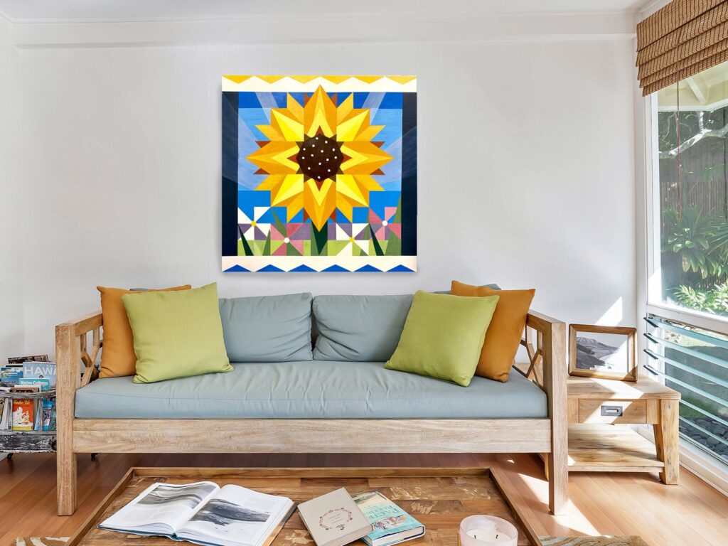 a barn quilt hanging on the wall, above the wooden sofa.