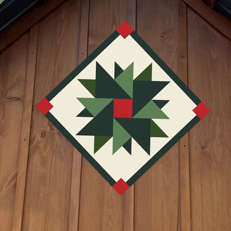 a barn quilt with blue star hanging on the wooden barn