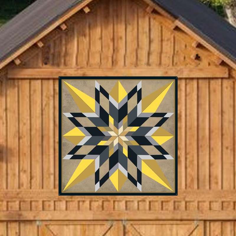 a barn quilt with black and yellow stars pattern hanging on the wooden wall