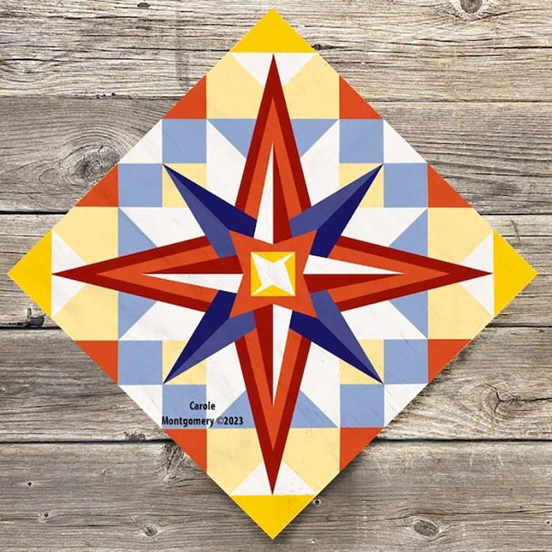 a barn quilt with red and blue star laying on the wooden floor