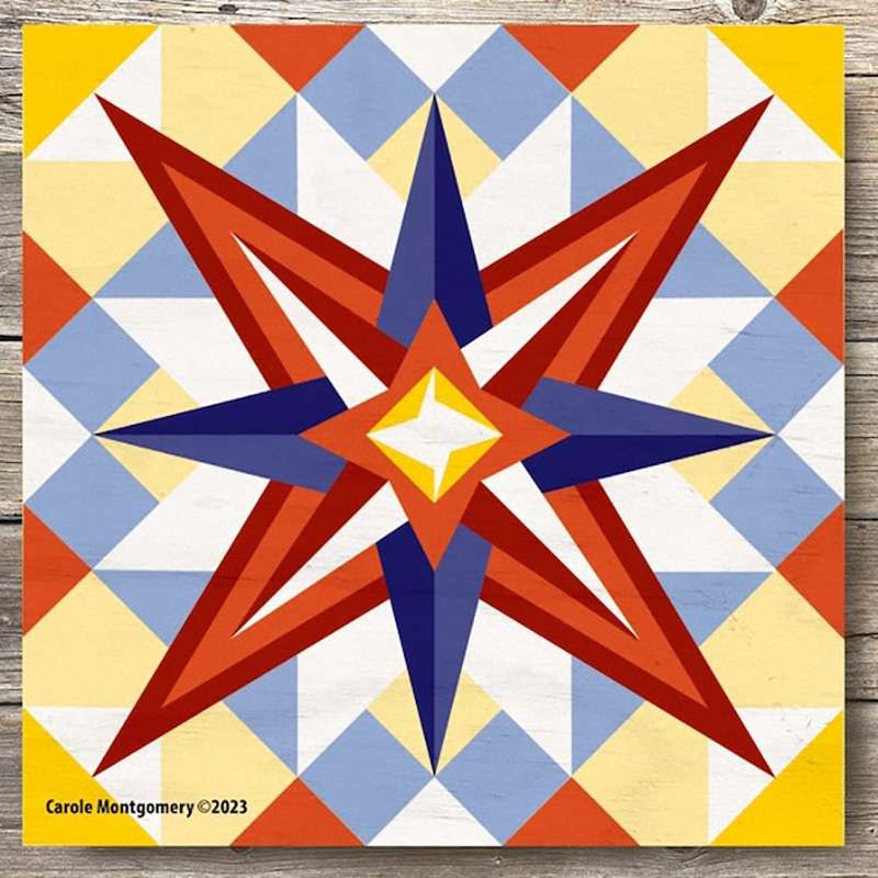 a barn quilt with red and blue star laying on the wooden floor