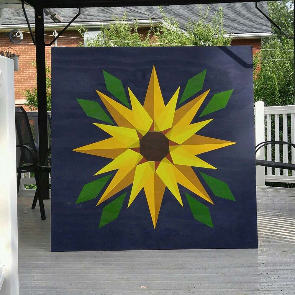 a sunflower barn quilt laying on the floor