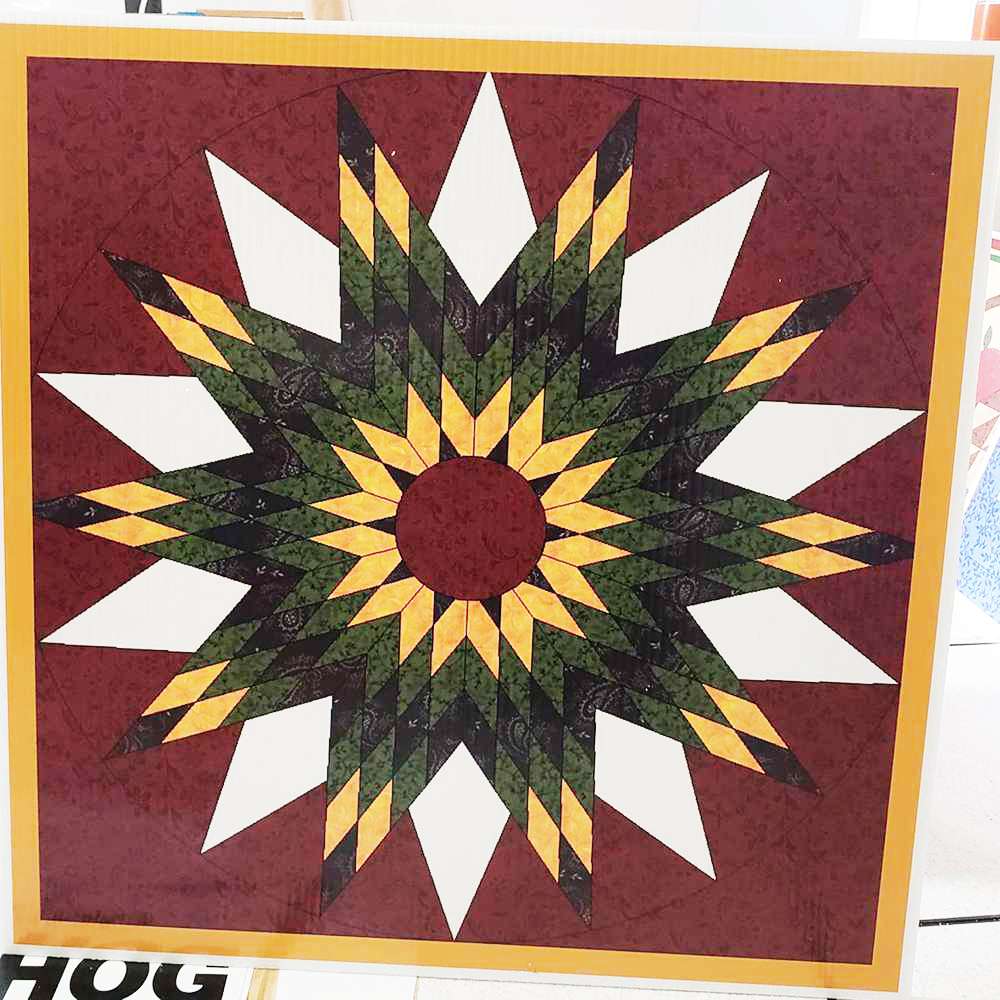 a sunflower barn quilt laying on the floor